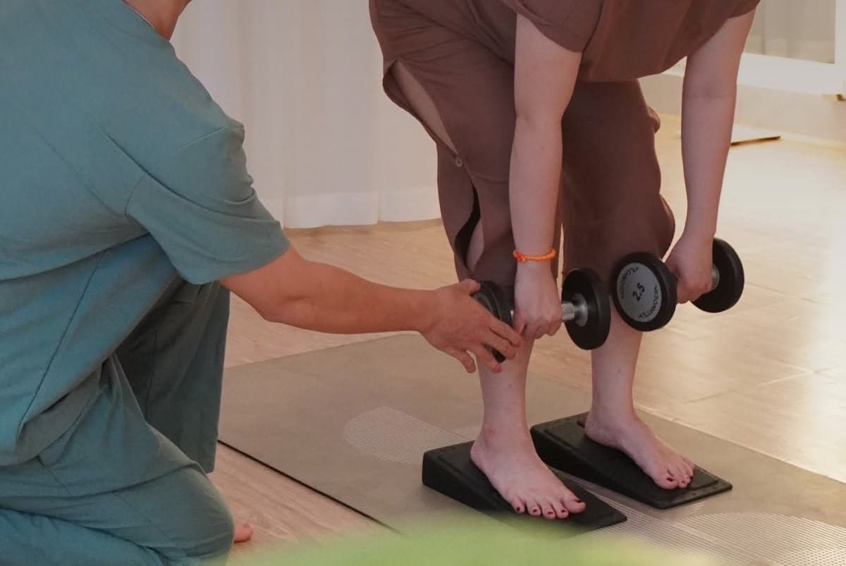 Chuyên viên Holistic hướng dẫn khách tập hạ tạ đơn đúng tư thế